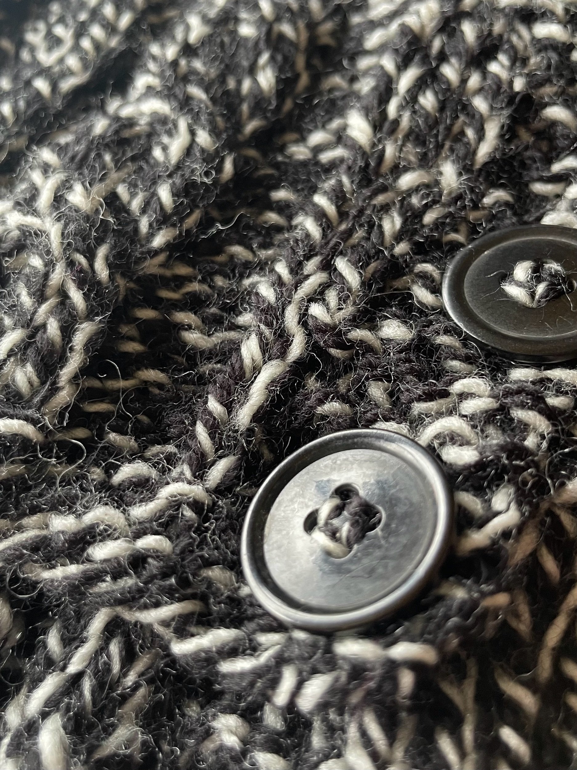 Close-up of a textured fabric with buttons on a dark background