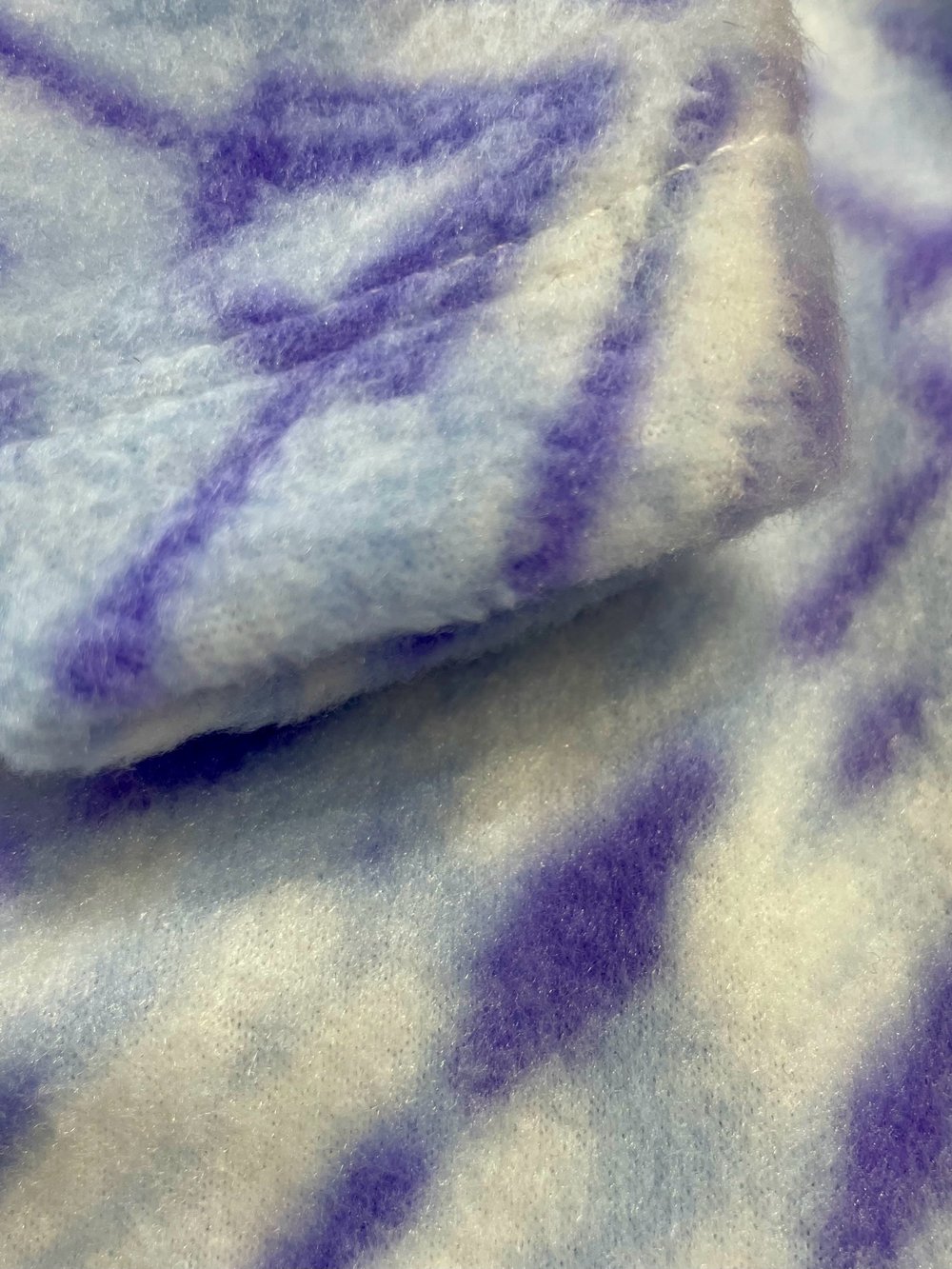 Close-up of a textured fabric with purple and white pattern