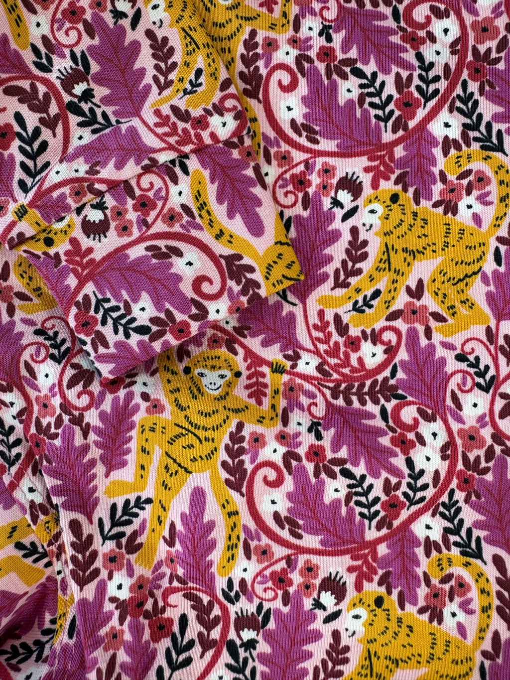 Patterned fabric with yellow leopards and pink foliage