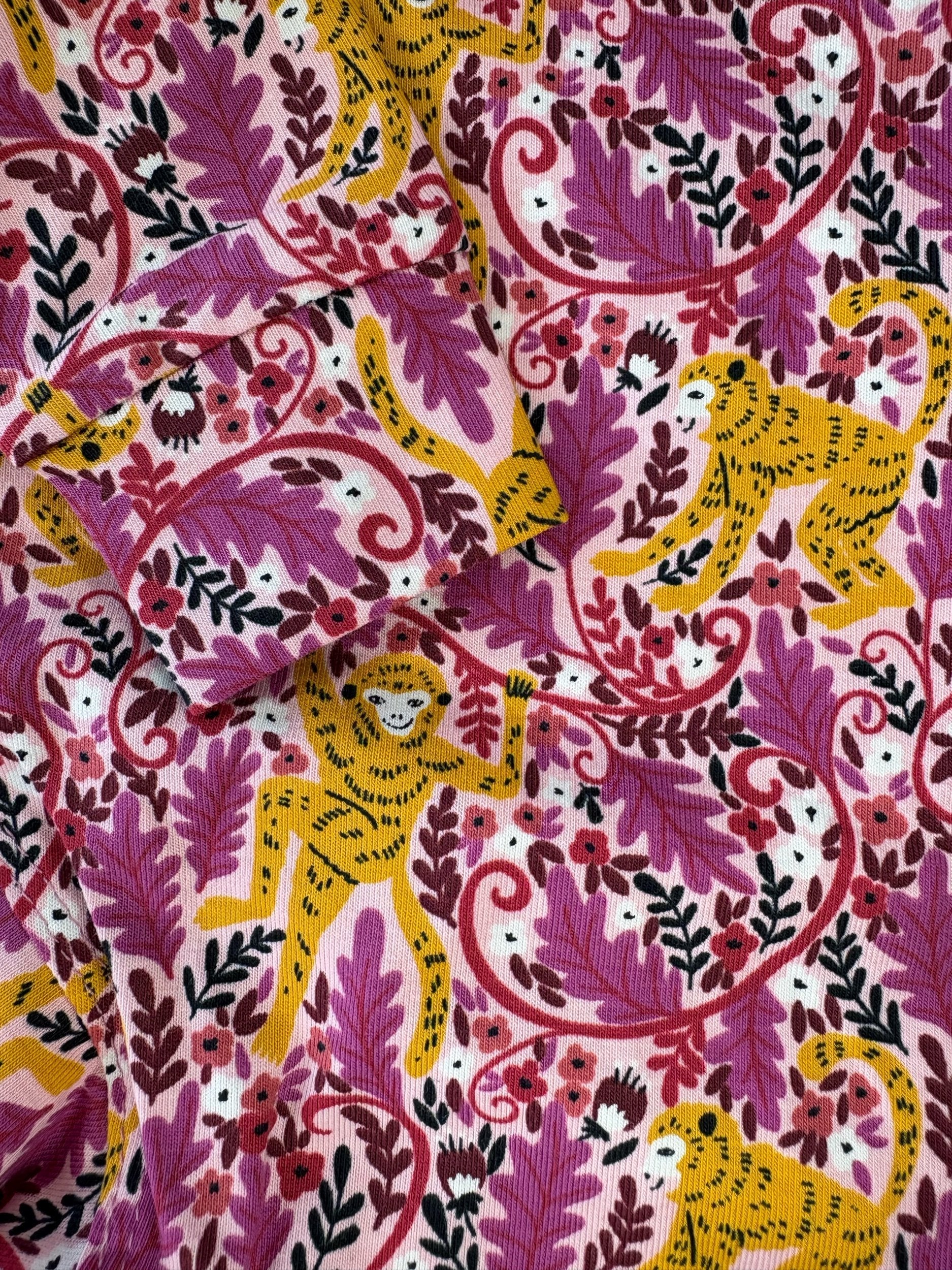 Patterned fabric with yellow leopards and pink foliage