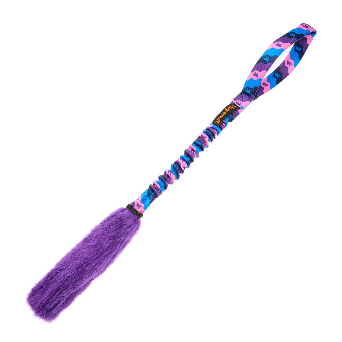 The Bright Fauxtastic Tug is a colorful dog toy with a looped handle, blue and pink patterned fabric, and a fluffy purple end—perfect for interactive playtime or recall training.