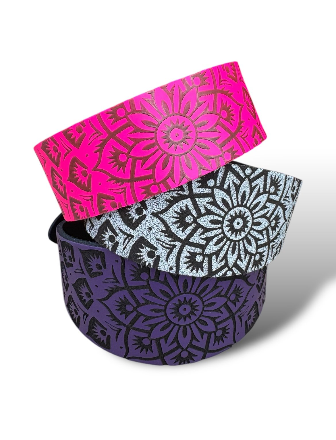 Three colorful patterned bags stacked on a white background