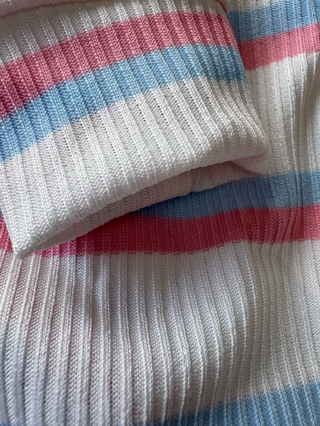 Close-up of a ribbed fabric with red and blue stripes on a white background