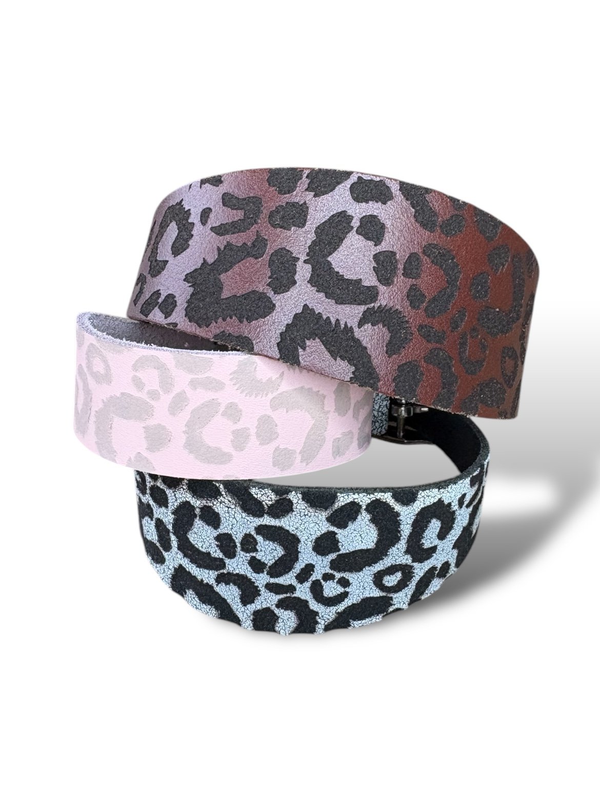 Three leopard print headbands in different colors on a white background
