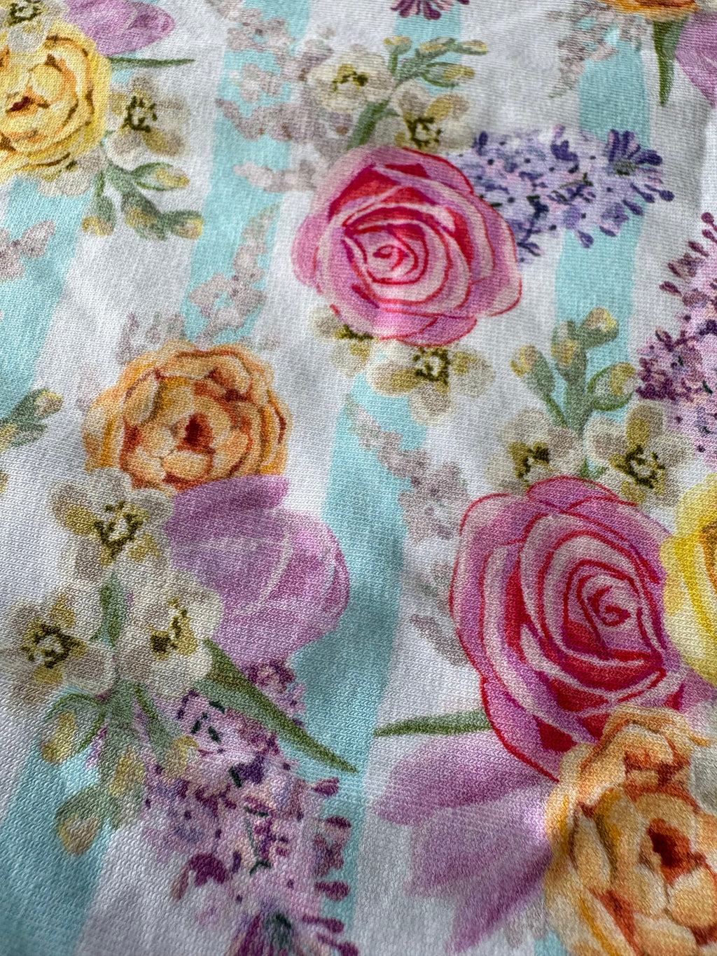 Close-up of floral fabric with roses and other flowers on a light background