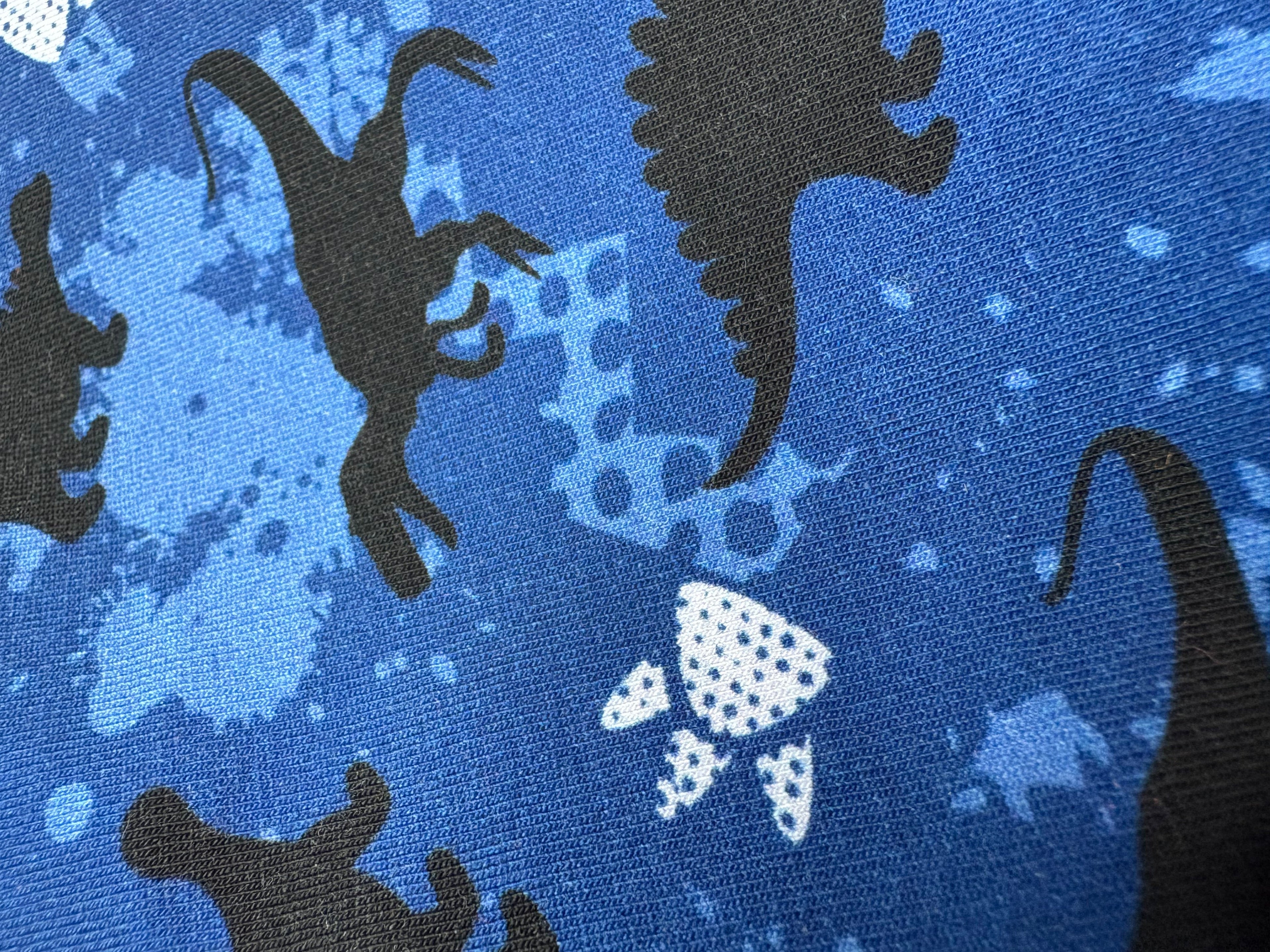 Black dinosaur silhouettes on a blue textured background