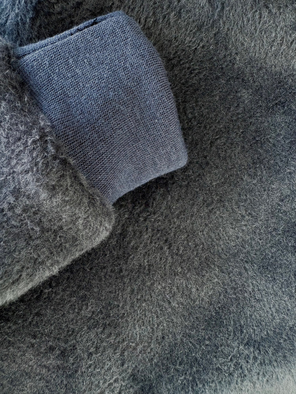 Close-up of gray textured fabric with a blue woven pattern