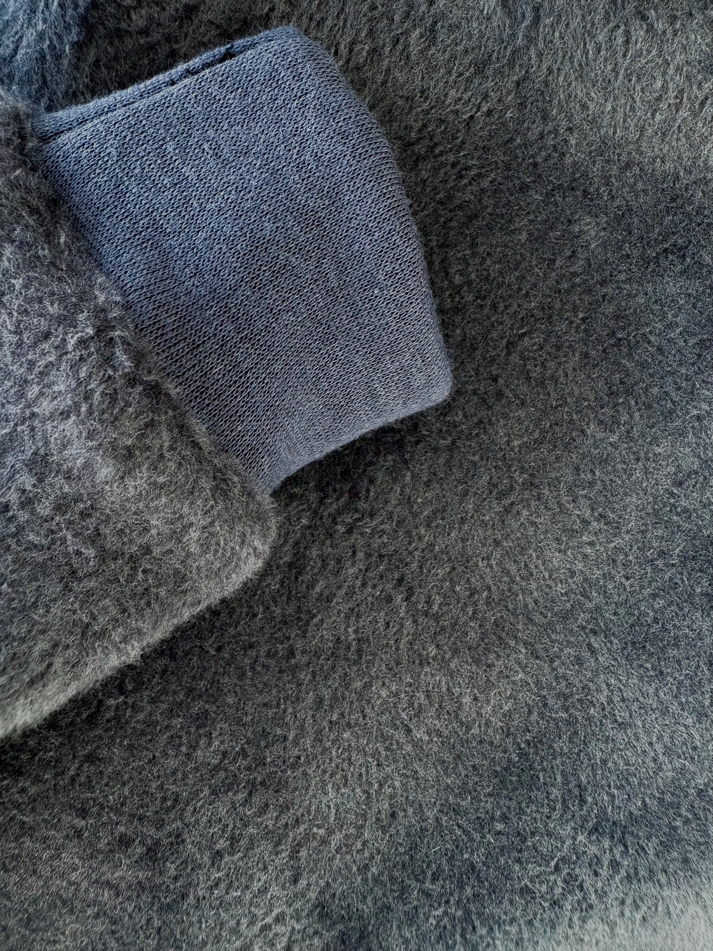 Close-up of gray textured fabric with a blue woven pattern