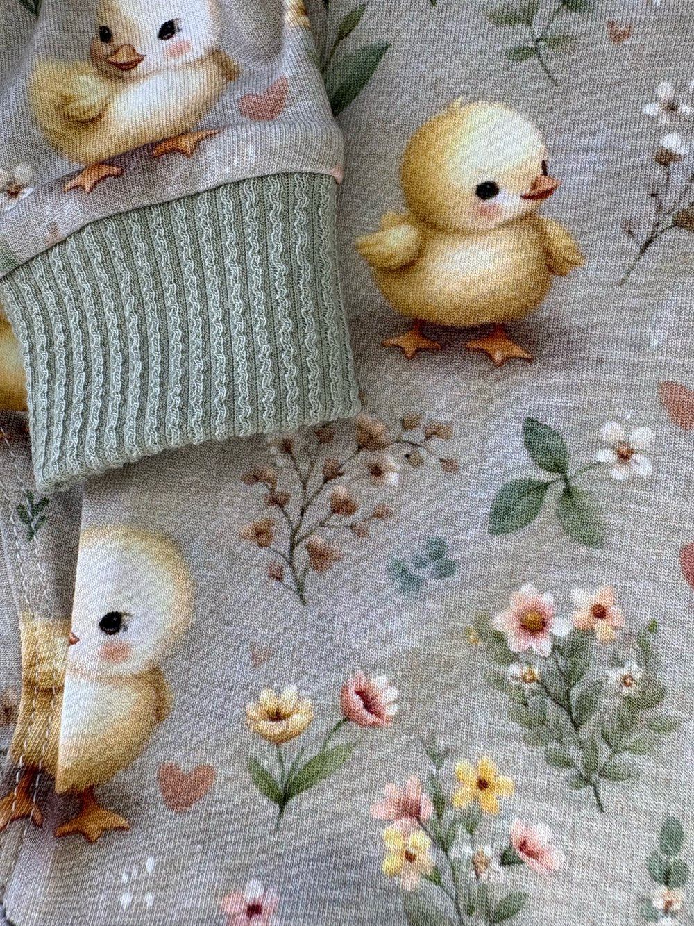Floral fabric with embroidered chicks and a green knitted item.