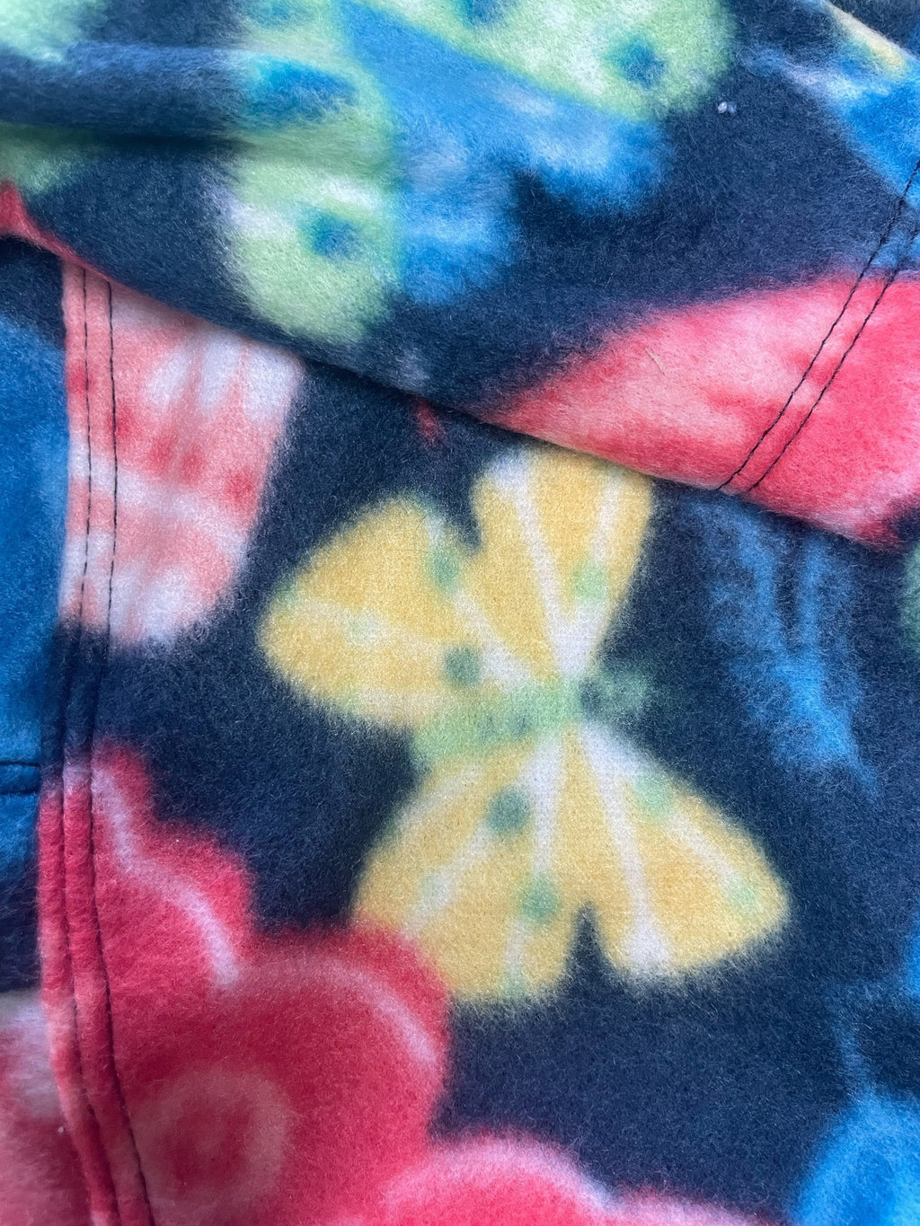 Close-up of a colorful tie-dye pattern with red, yellow, and blue colors.