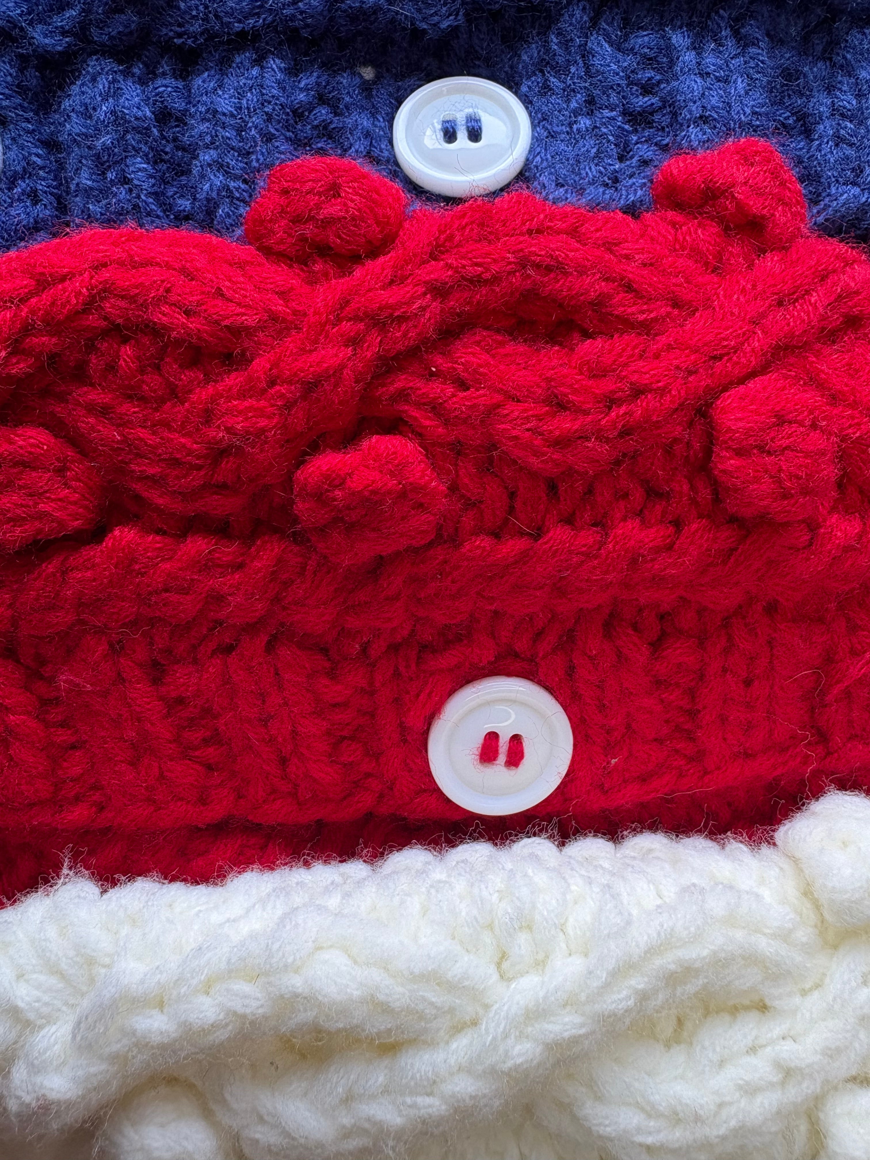 Close-up of a red, white, and blue knitted fabric with buttons.