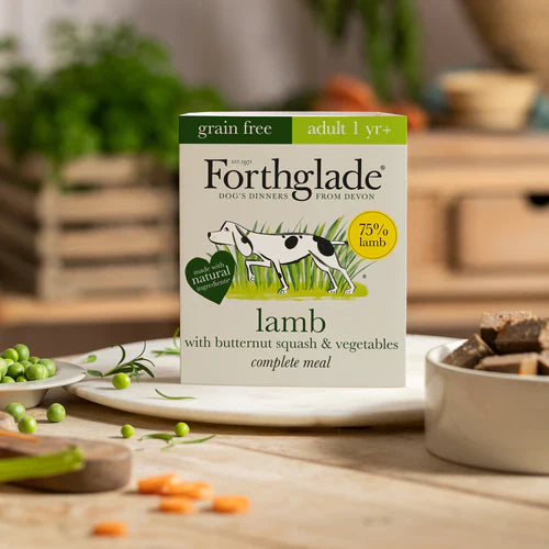 Forthglade dog food package on a wooden table with vegetables and a blurred background