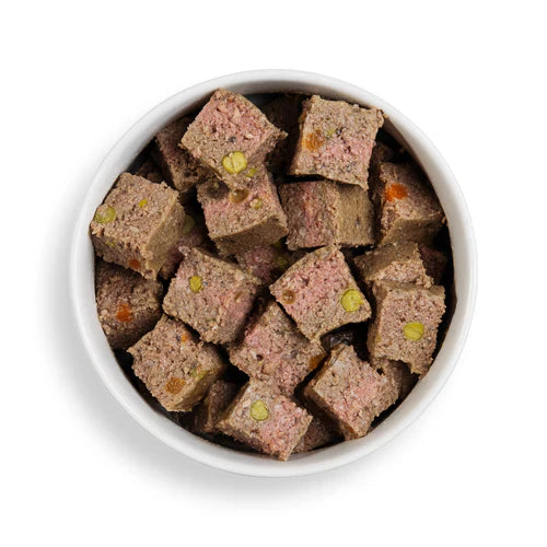 White bowl filled with square-shaped pet treats on a white background