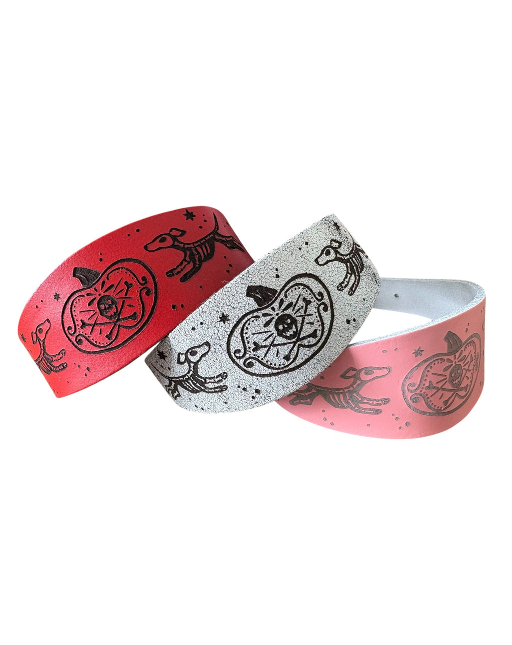Two wristbands, one red and one gray, with black designs on a white background
